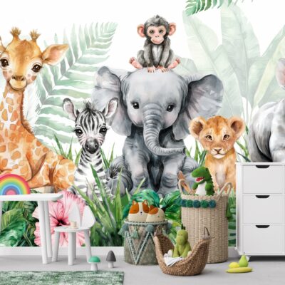 tapeta ścienna dla dzieci przedstawiająca grupę uroczych zwierząt safari: żyrafę, słonia z małpką na głowie, zebrę, lwiątko i nosorożca, otoczonych bujną tropikalną roślinnością z dużymi zielonymi liśćmi i różowymi kwiatami. Na pierwszym planie widoczne są meble dziecięce: biały stolik z krzesełkami i małą tęczą, kosze na zabawki oraz biała komoda.