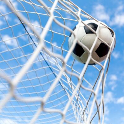 Fototapeta dla dzieci piłka nożna w siatce bramki na tle nieba.