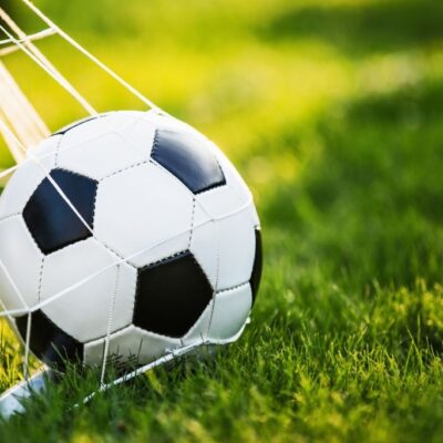 fototapeta do pokoju chłopca przedstawiająca piłkę nożną w bramce i trawę.