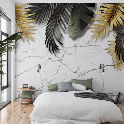 Zdjęcie sypialni z dużym oknem i drewnianym parkietem. Ściana za łóżkiem pokryta jest fototapetą z wzorem białego marmuru. Z górnych rogów i boków wyłaniają się duże liście palmowe – część z nich jest w kolorze błyszczącego złota, a część w odcieniach głębokiej czerni i grafitu. Pościel na łóżku jest biała z zielonymi akcentami, co harmonizuje z roślinnym motywem.