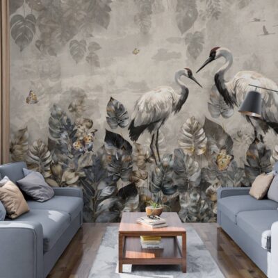 obrazek przedstawiający na ścianie tapetę dwie stojące czaple na szarym betonowym tle i na dole czarno złote liście i roślinność. Na środku stolik kawowy a po obu stronach szara kanapa.