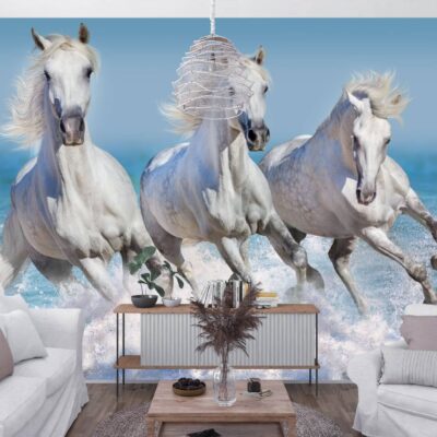 Obrazek przedstawiający salon. Na środku stolik kawowy po bokach białe kanapy a na wprost na drugim planie ściana z fototapetą przedstawiającą białe konie biegnące brzegiem morza.
